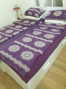 a bed with a purple and white quilt on it at A Place To Remember in Ma‘alot