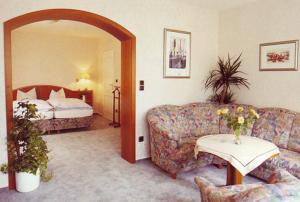 Hotel Sonnenhof في باد ساخسا: غرفة معيشة مع أريكة وسرير