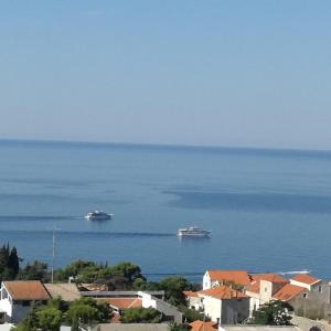 due imbarcazioni in acqua con case ed edifici di Apartments Đivanović a Dubrovnik