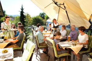 eine Gruppe von Personen, die in einem Restaurant an Tischen sitzen in der Unterkunft Hotel Alter Weißbräu in Bad Birnbach