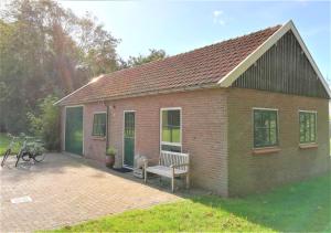 a small brick building with a bench in the yard at Sluizeweidje Texel in Den Burg