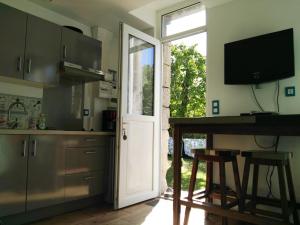 a kitchen with a door and a table and a television at Le Presbytère in Les Ageux