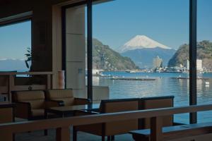 a view of a mountain from a room with a table and chairs at Izu Mitohama Shotokan in Numazu