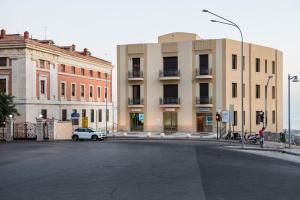 samochód jest zaparkowany na ulicy przed budynkami w obiekcie Deluxe apartment Milia Agrigento w mieście Agrigento