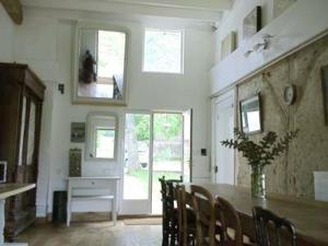 a dining room with a table and a vase of flowers at Lilac cottage in La Haye