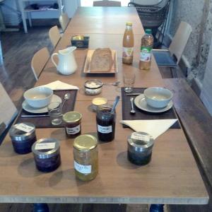 drewniany stół ze słoikami, talerzami i napojami w obiekcie Lilac cottage w mieście La Haye +4 zdjęcia