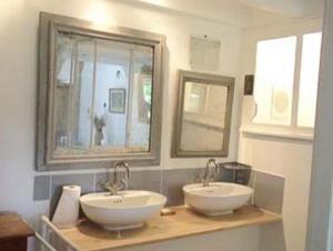 un bagno con due lavandini e due specchi di Lilac cottage a La Haye