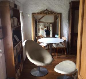 a room with a table and chairs and a mirror at Lilac cottage in La Haye