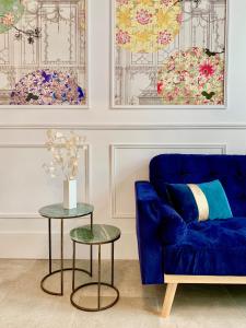 un soggiorno con divano blu e 2 tavoli di Home Chic Home - Les Suites de La Comédie a Montpellier