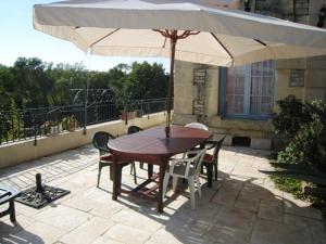 - une table et des chaises en bois avec un parasol sur la terrasse dans l'établissement Chateau Du Comte, à Saint-Nazaire-dʼAude