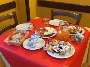 une table rouge avec des assiettes de nourriture dans l'établissement Il Bucaneve, à Barrea