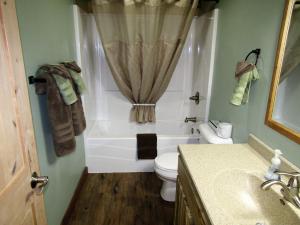 a bathroom with a tub and a toilet and a sink at Freedom Ridge Cabins in Hill City +40 photos