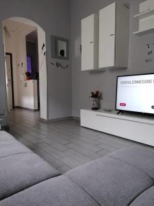 - un salon avec une télévision et des placards blancs dans l'établissement Casa Normanna, à Monreale