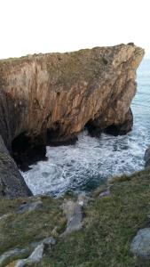 una gran formación rocosa junto al océano en Apartamentos Borizu Playa, en Barro de Llanes