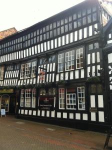 a black and white building with windows on a street at Crown Hotel in Nantwich