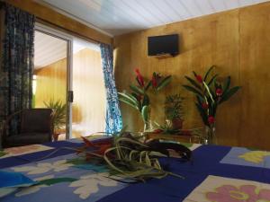 Una habitación con una mesa con flores. en Fare Ara Location Huahine en Fare