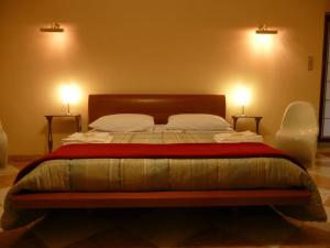 una camera da letto con un letto con due luci sul muro di L'aura di Sicilia a Ragusa