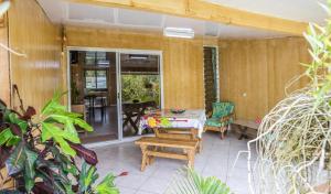 una veranda riparata con tavolo e sedie di Fare Ara Location Huahine a Fare (Huahine Nui)