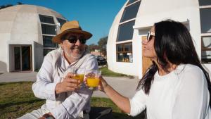 a woman and a man holding glasses of orange juice at Hotel Domos Dream in La Serena