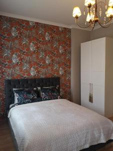 ein Schlafzimmer mit einem Bett und einer roten Wand in der Unterkunft Best Apartments Więzienna Monkeys in Breslau