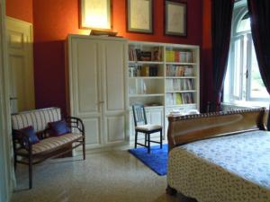 a bedroom with a bed and a couch and a book shelf at Villa V in Brescia