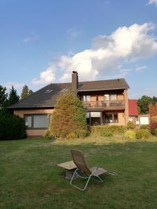 een stoel in het gras voor een huis bij Domizil & Dümmer in Lembruch