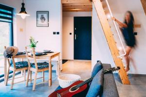 a woman climbing a ladder in a living room at Domki 4 Nad Ranem - Baza Bieszczady Smerek in Smerek