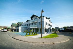 un edificio blanco al lado de una calle en STOP Apartment, en Suwałki