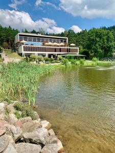 a building next to a body of water at Domki Szarlota - atrakcje dla rodzin na Kaszubach in Kościerzyna