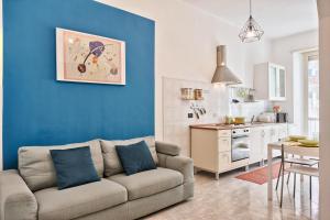 ein Wohnzimmer mit einem Sofa und einer blauen Wand in der Unterkunft Lingotto Home in Turin