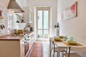 eine Küche mit einem Tisch mit Stühlen und einer Arbeitsplatte in der Unterkunft Lingotto Home in Turin
