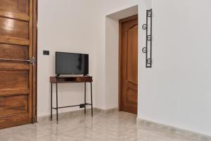 einen Fernseher auf einem Tisch neben einer Tür in der Unterkunft Lingotto Home in Turin