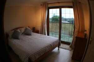 a bedroom with a bed and a large window at Hooters Apartment EV Point in Wadebridge