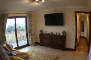 a living room with a flat screen tv and a couch at Hooters Apartment EV Point in Wadebridge