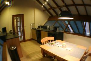 a dining room with a table and a kitchen at Hooters Apartment EV Point in Wadebridge