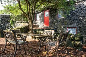 une table et des chaises devant un bâtiment en pierre dans l'établissement Aldeia Dos Caldeirões, à São Mateus