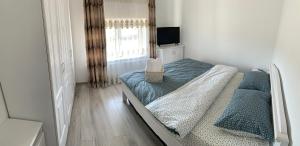 um pequeno quarto com uma cama e uma janela em Apartament 23 em Sebeş