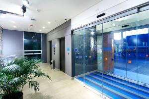 麦德林ibis budget Medellín Itagüí Metro的一座带玻璃墙的建筑中的室内游泳池