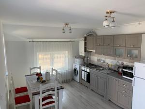 a kitchen with gray cabinets and a table and a counter at Apartament 23 in Sebeş