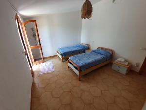 Habitación con 2 camas y espejo. en Villetta immersa nella tranquillità, en Capitana