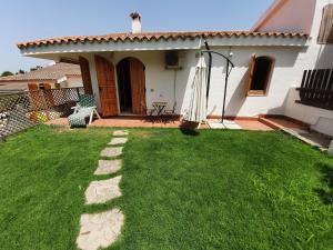 a backyard with a grass yard and a house at Villetta immersa nella tranquillità in Capitana
