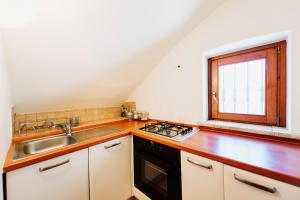 a kitchen with a sink stove and a window at CASALE AL LAGO con PISCINA E SAUNA in Corbara