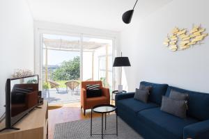 un soggiorno con divano blu e sedie di Douro Virtudes Apartments Historical Center a Porto