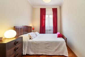 sypialnia z łóżkiem i oknem z czerwonymi zasłonami w obiekcie Casa da Avó Amália w mieście Janeiro de Cima