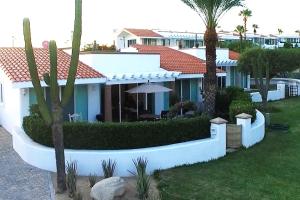 una casa blanca con palmeras delante en Cabo Cottage Villa Neptuno Charming Villa in Cabo Quiet View Ocean Community en Cabo San Lucas