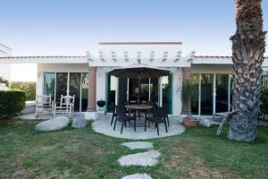 a patio with a table with chairs and an umbrella at Cabo Cottage Villa Neptuno Charming Villa in Cabo Quiet View Ocean Community in Cabo San Lucas