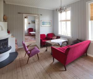 een woonkamer met roze meubels en een open haard bij Nedre Eie in Lunde
