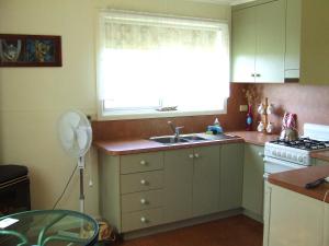 cocina con fregadero y ventana en Bushland Retreat, en Cape Bridgewater