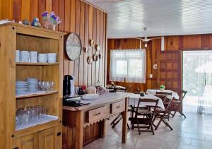 cocina con paredes de madera, mesa y sillas en Pousada Renascer en Ilha do Mel