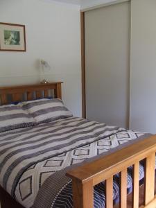 um quarto com uma cama com uma estrutura em madeira em Bushland Retreat em Cape Bridgewater
